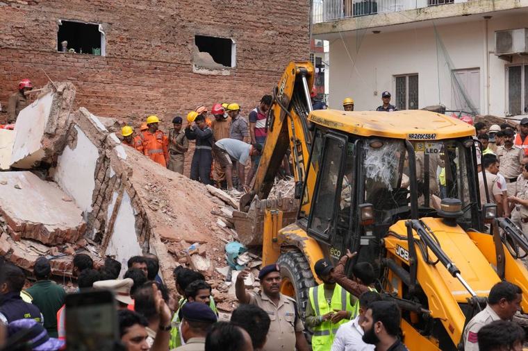 Building collapse in New Delhi kills 1 and traps dozens of others